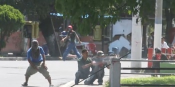 Mario Belloso apuntó con un fusil durante los enfrentamientos frente a la Universidad de El Salvador, el 5 de julio de 2006. Esta imagen fue clave en la identificación del atacante (Cortesía LPG).
