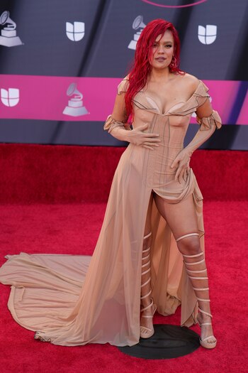 Karol G con su larga cabellera en color rojo, con un vestido que dejó ver sus curvas en la alfombra roja de los Latin Grammy 2022 - crédito John Locher/AP