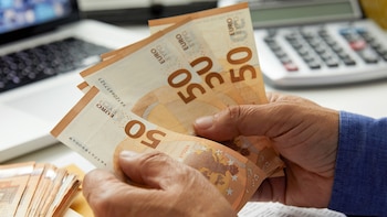 Un trabajador contando billetes de