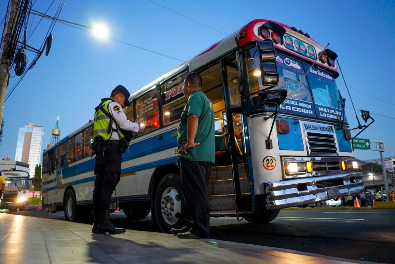 Un agente de tránsito inspecciona un autobús del transporte colectivo en una calle de San Salvador, como parte de los controles a las unidades que operan en la capital (Foto cortesía VMT).