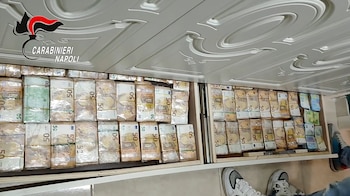 Billetes ocultos en una pared en Caivano, en un operativo que también permitió incautar fusiles Kalashnikov y 11 relojes Rolex (Carabineros italianos/vía AFP)