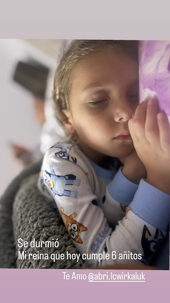 Primer plano de una niña de cabello claro durmiendo placenteramente. Tiene la mejilla sobre una almohada morada y viste un pijama estampado