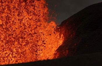 Esta vista telefoto de la fuente de lava del cráter norte durante el episodio 49, el 14 de junio de 2026, muestra la lava incandescente cayendo sobre la pared del cráter Halema'uma'u e iluminándola. - Crédito: Foto del USGS por T. Paladino.
