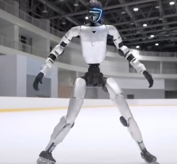 Un robot humanoide bipedal, de color plateado y negro con un visor azul brillante en la cabeza, se encuentra en postura de patinaje sobre una pista de hielo blanca