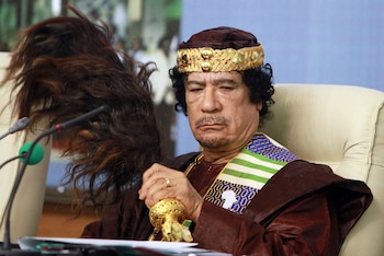 El líder libio Moammar Gadhafi se abanica durante el Foro de Reyes, Príncipes, Sultanes, Jeques y Alcaldes de África, en Trípoli, el 8 de septiembre de 2010. (AP Foto/Abdel Magid Al Fergany, archivo)