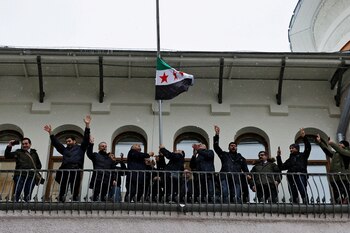 Personas que se presentaron como miembros de la diáspora siria instalan la bandera de la oposición siria (REUTERS/Yulia Morozova)