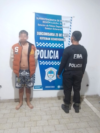 Dos personas, con rostros pixelados, sostienen pistolas y revólveres en una foto. Uno lleva capucha y bufanda; el otro está parcialmente visible. El fondo es oscuro