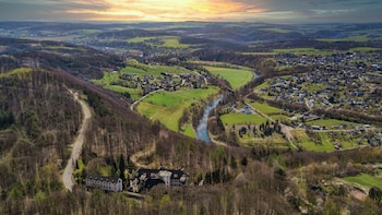 Vista aérea de Windeck-Rosbach, con el río Sieg, zonas verdes, viviendas y el antiguo sanatorio pulmonar en primer plano.