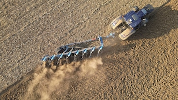 Un agricultor conduce un tractor