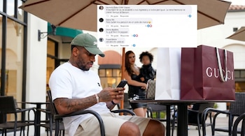 Hombre (Jefferson Farfán) sentado en una mesa de café al aire libre, mirando su teléfono. Tiene tatuajes en los brazos, lleva gorra verde y camiseta blanca. Cerca hay una bolsa Gucci.