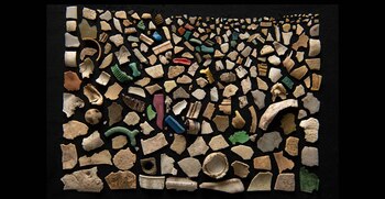 Múltiples fragmentos de plástico de varios colores y formas dispuestos en hileras sobre una superficie negra