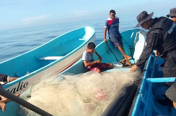 Agentes policiales inspeccionan barcos pesqueros