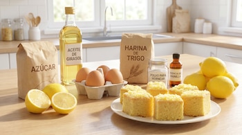 Ingredientes de repostería como limones partidos, azúcar, aceite de girasol, huevos, harina, polvo para hornear y vainilla, junto a porciones de bizcocho en una cocina.