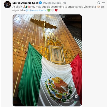 Una bandera de México cuelga frente a un altar con una cruz dorada y un cuadro de la Virgen de Guadalupe
