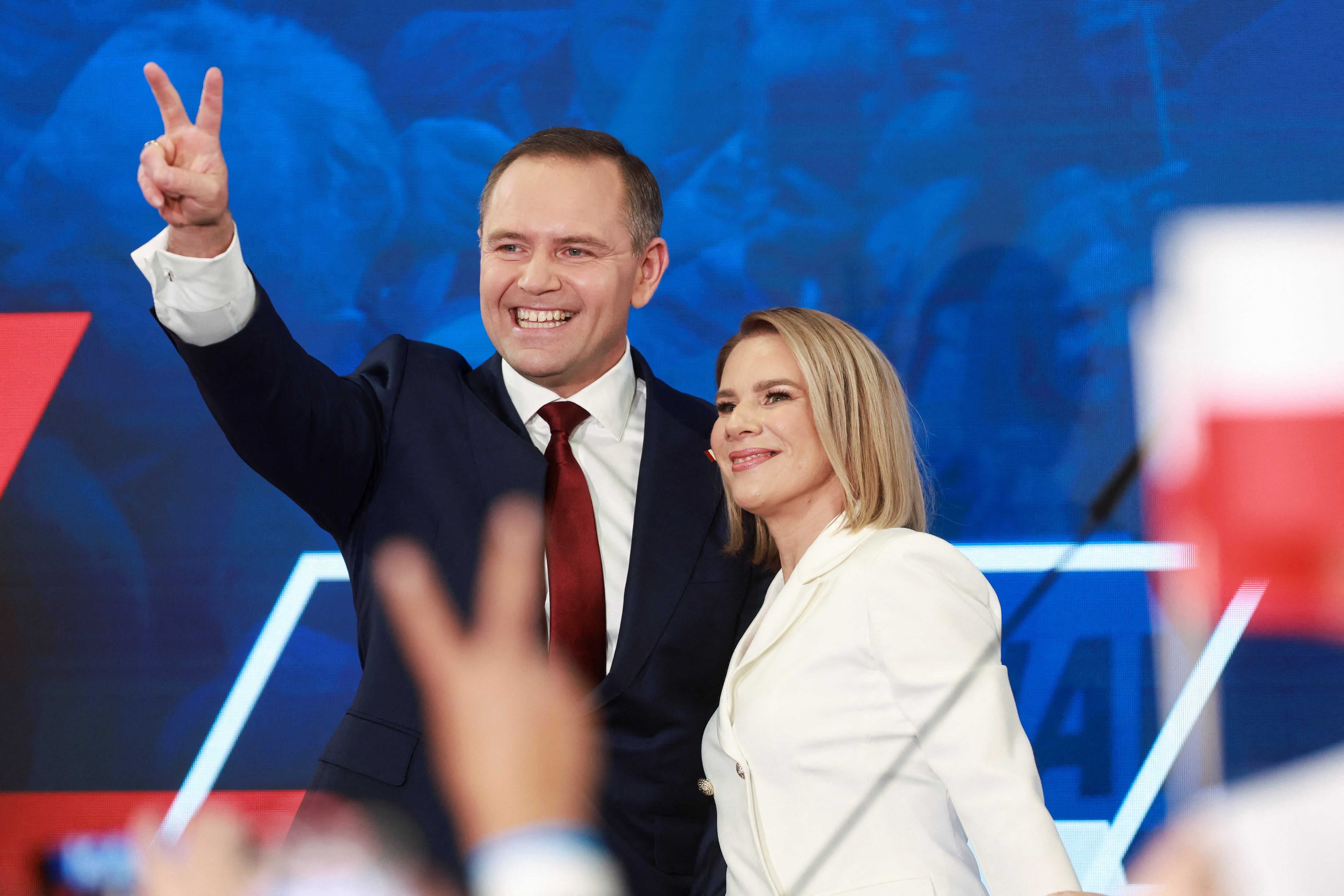 Karol Nawrocki, candidato presidencial polaco apoyado por el principal partido de oposición, Ley y Justicia (PiS), y su esposa Marta Nawrocka reaccionan a las encuestas de salida para la primera vuelta de las elecciones presidenciales de Polonia, en Gdansk, Polonia, el 18 de mayo de 2025. REUTERS/Lukasz Glowala
