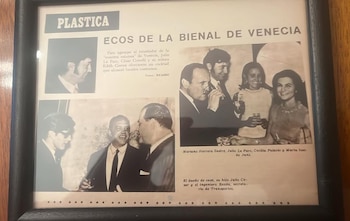 Una fotografía en blanco y negro enmarcada de un recorte de periódico, mostrando varias imágenes de un cóctel con gente sonriendo y la noticia de la Bienal de Venecia