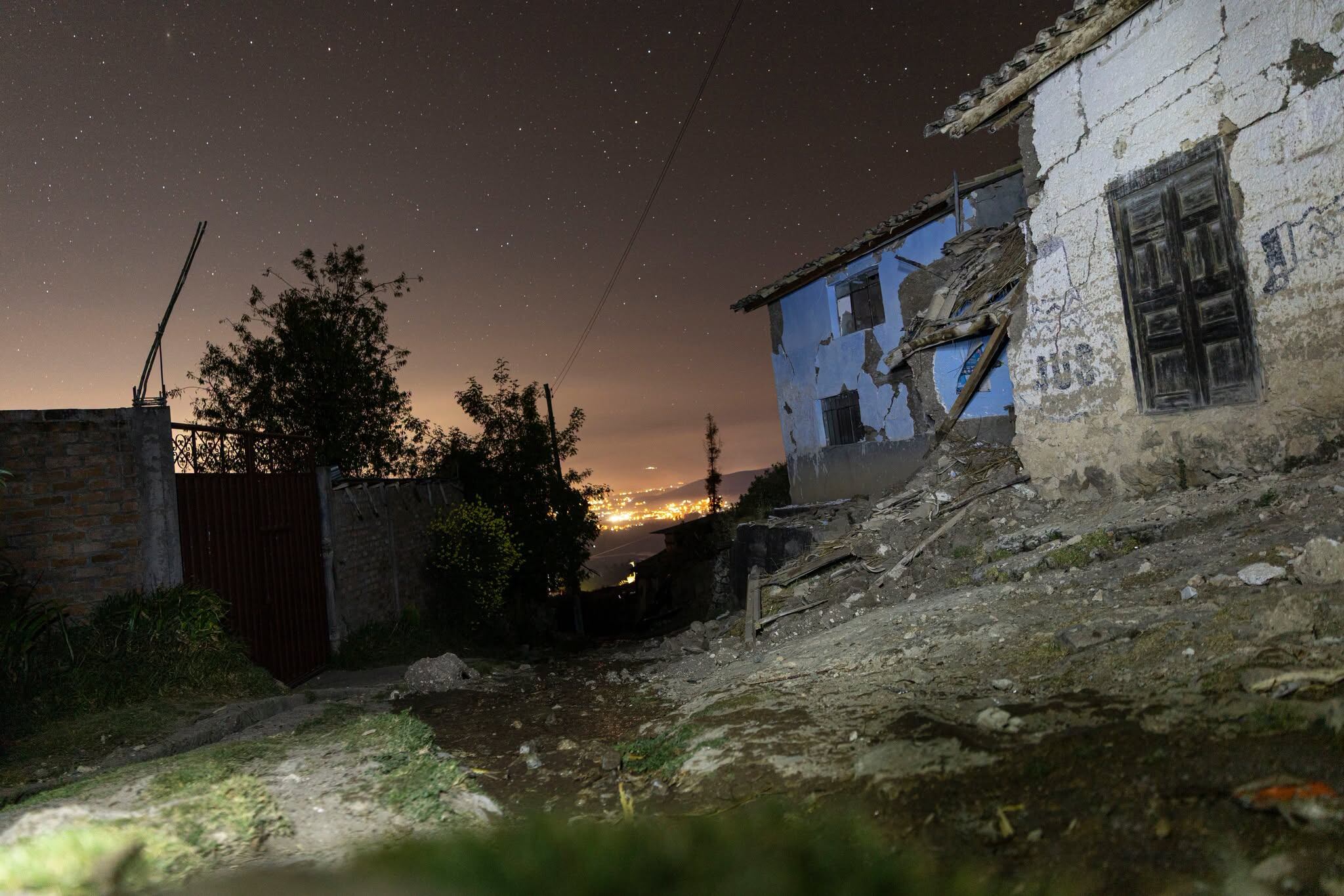 Viviendas con estructuras deterioradas y escombros en un terreno irregular durante la noche, en una zona afectada por un sismo en Junín, Perú. (Wayka / Javier Ninanya y Yershon Vilca)