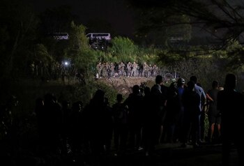 Soldados de la Guardia Nacional de Texas hacen guardia cerca de las orillas del río Bravo mientras los solicitantes de asilo intentan cruzar la frontera para entregarse a los agentes de la Patrulla Fronteriza de Estados Unidos mientras se levanta el Título 42, en Matamoros, México, 11 de mayo de 2023. REUTERS/Daniel Becerril