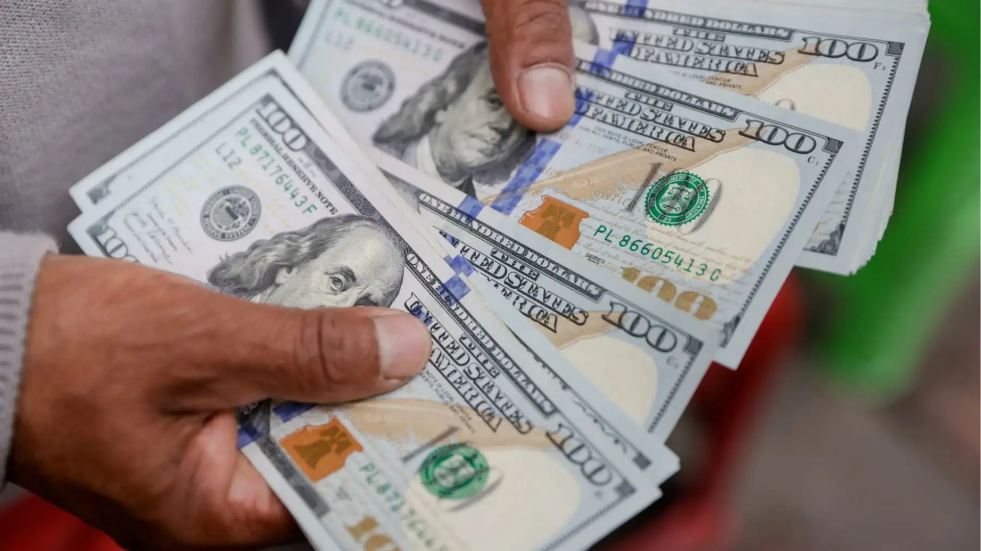 Una persona cuenta billetes de dólares estadounidenses en el contexto del tipo de cambio oficial que publica la SUNAT en Perú. (Agencia Andina)