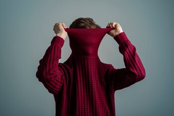 Young Man pulling red sweater