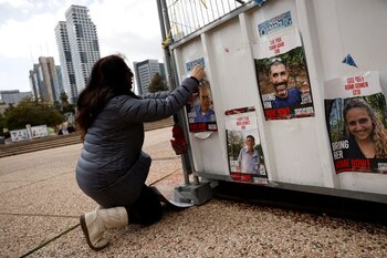 Dahlia Cooper cuelga una foto de su suegro Amiram Cooper, secuestrado en el mortífero atentado del 7 de octubre por el grupo islamista palestino Hamas, en Tel Aviv (REUTERS/Susana Vera)