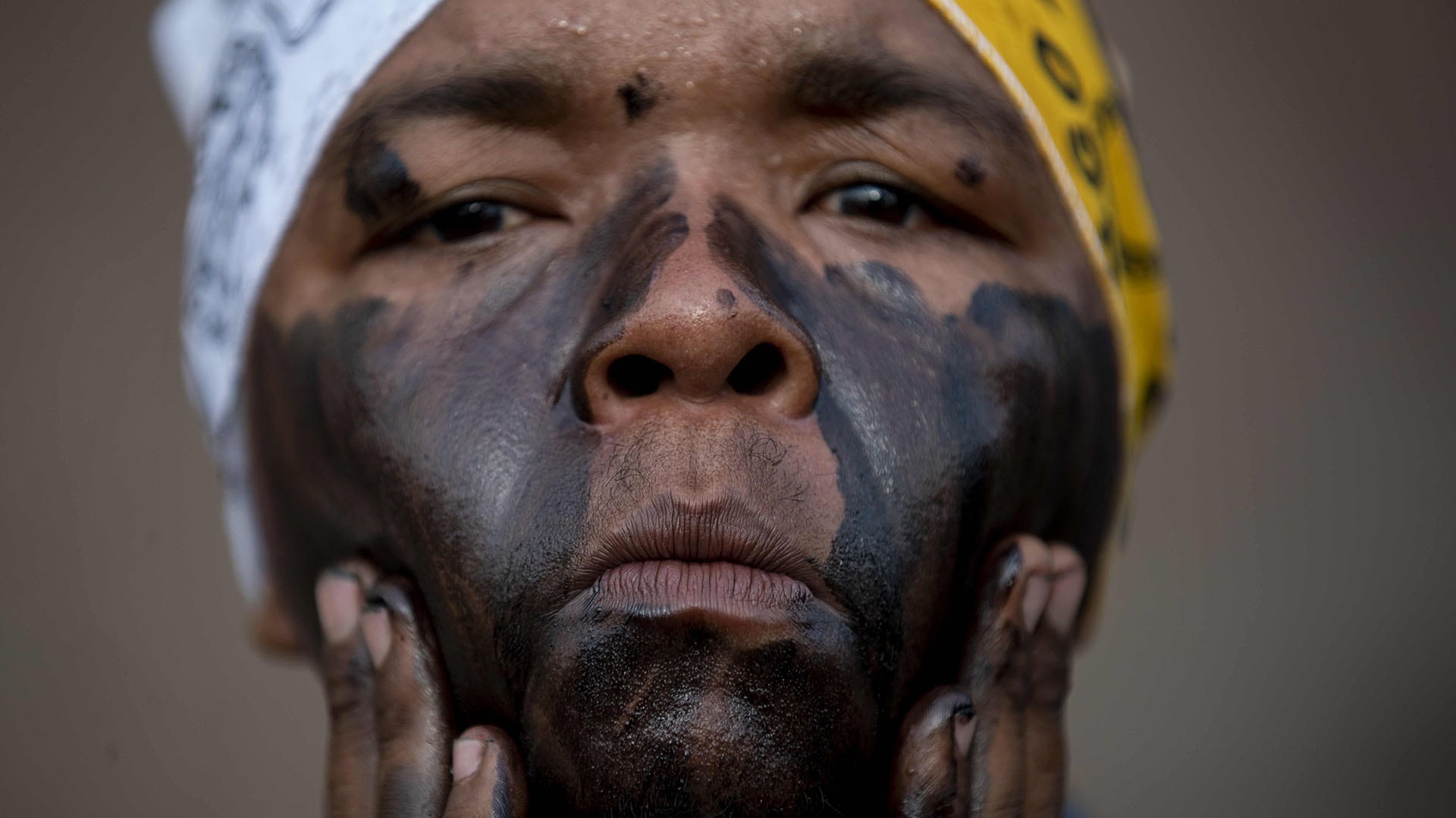 NI5014. MANAGUA (NICARAGUA), Un promesante pinta su cara con aceite negro durante una vigilia en honor a Santo Domingo de Guzmán en Managua (Nicaragua). EFE/Jorge Torres.
