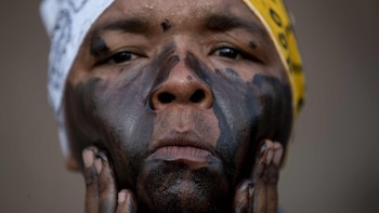 NI5014. MANAGUA (NICARAGUA), Un promesante pinta su cara con aceite negro durante una vigilia en honor a Santo Domingo de Guzmán en Managua (Nicaragua). EFE/Jorge Torres.
