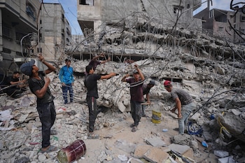 Palestinos retiran hierro de los escombros de edificios destruidos por ataques aéreos israelíes durante la guerra con Hamás, para reparaciones y reciclarlo para construir carpas o venderlo, en Ciudad de Gaza, el domingo 16 de agosto de 2026. (AP Foto/Jehad Alshrafi)