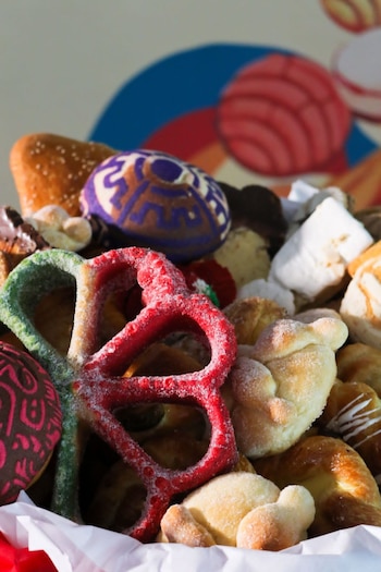 Diversas piezas de pan dulce y galletas con azúcar de colores rojo y verde, glaseado blanco y decoraciones de chocolate