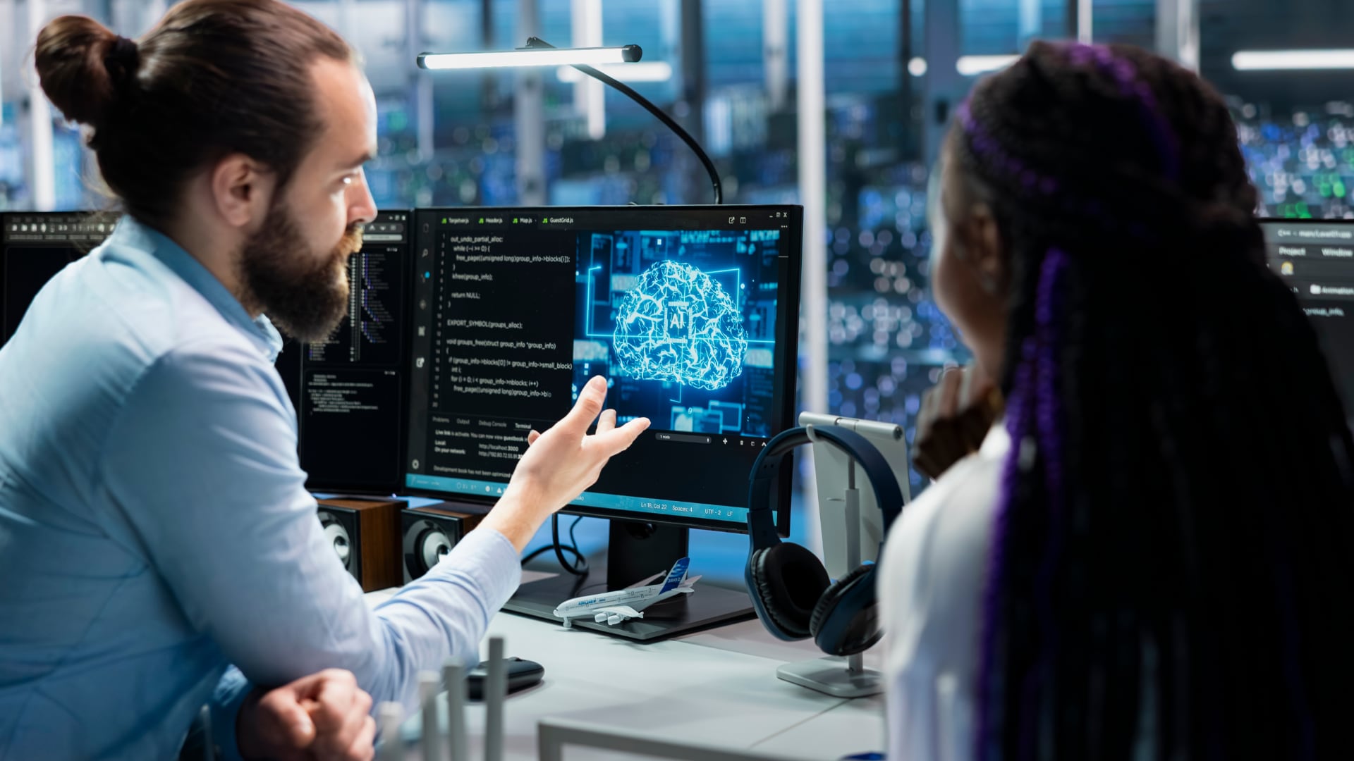 Dos trabajadores observan una representación de inteligencia artificial en un monitor dentro de una oficina, entorno en el que su uso se ha extendido en Lima Metropolitana. (Imagen Ilustrativa Infobae)