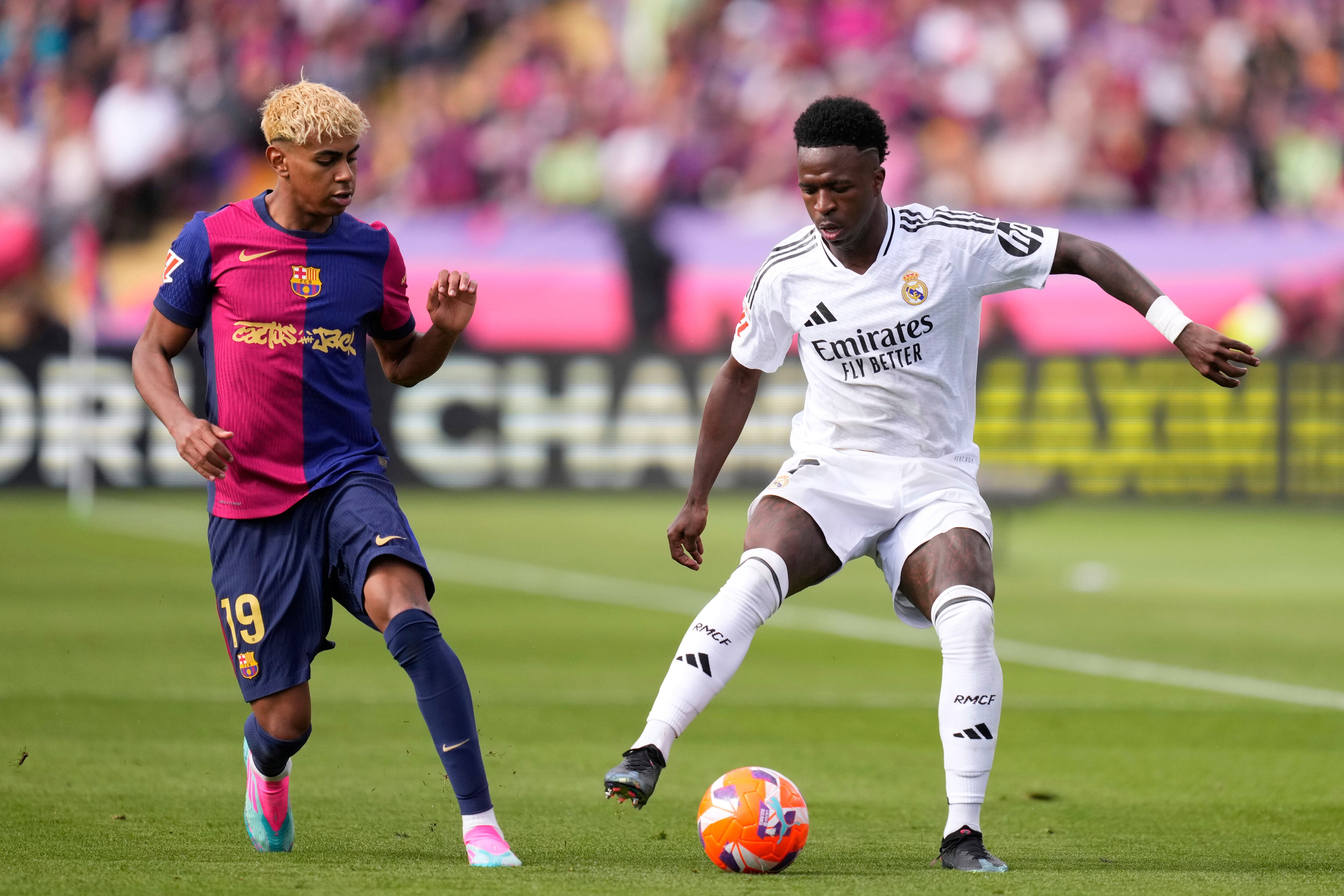 Vinicius Júnior (derecha) del Real Madrid y Lamine Yamal del Barcelona pugnan por el balón en el partido de la Liga española, el domingo 11 de mayo de 2025, en Barcelona. (AP Foto/José Bretón)
