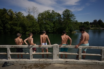 Varios niños se preparan para saltar al río Sena en Samois-sur-Seine, al sur de París, el viernes 19 de junio de 2026 (AP Foto/Thibault Camus)