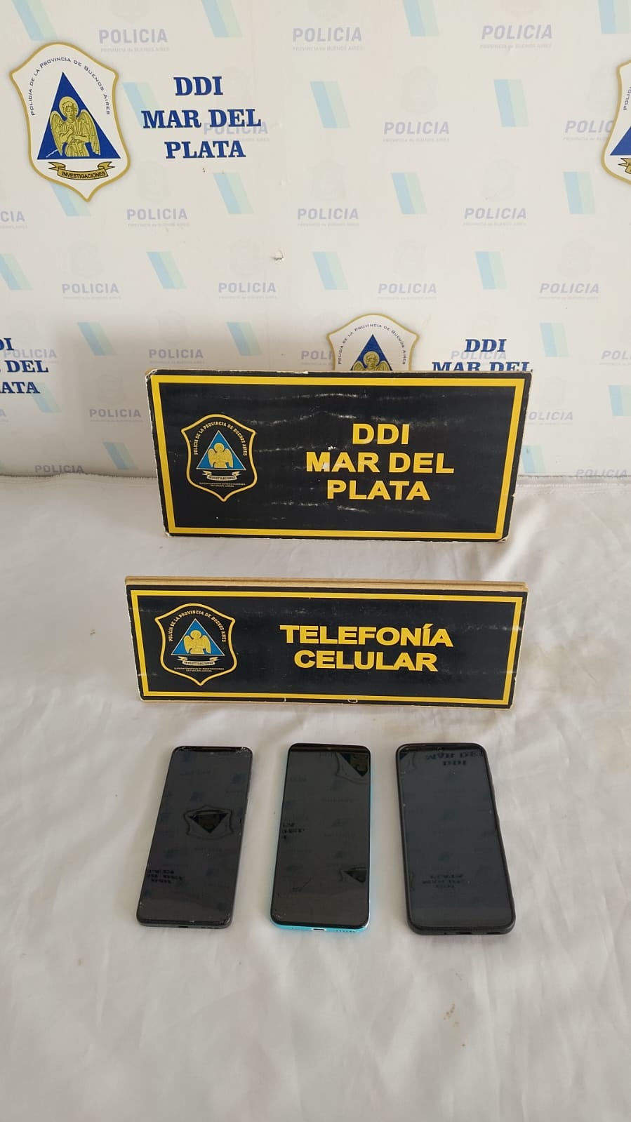 Los tres celulares incautados durante el allanamiento: uno pertenece a una de los jubilados