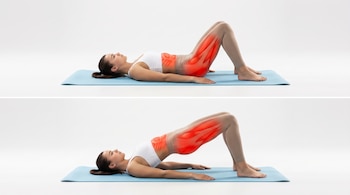 Mujer con top blanco y calza beige sobre colchoneta azul, realizando el ejercicio de puente de glúteos en dos fases. Abdomen, glúteos e isquiotibiales están resaltados en rojo.