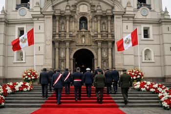 Fachada de la Catedral de Lima con dos banderas peruanas, alfombra roja en los escalones, arreglos florales y personas vestidas de traje y uniforme militar.
