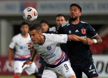 Ramón Arías (d) de Universidad de Chile disputa un balón con Franco di Santo de San Lorenzo hoy, en un partido de la Copa Libertadores en el estadio Nacional en Santiago (Chile). EFE/Esteban Félix
