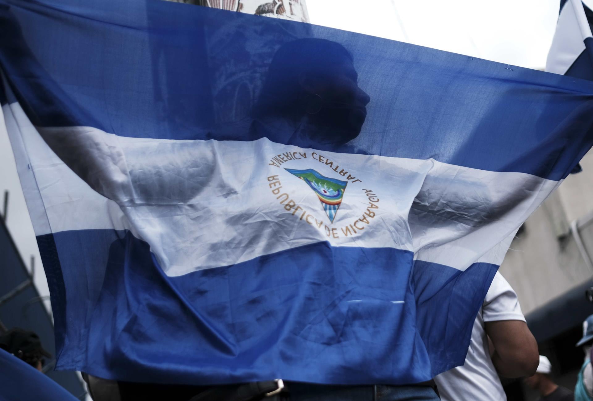 Un manifestante sostiene la bandera de Nicaragua durante una protesta en apoyo a la libertad de prensa.