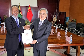 Charlot Salwai (izq.), estrechando la