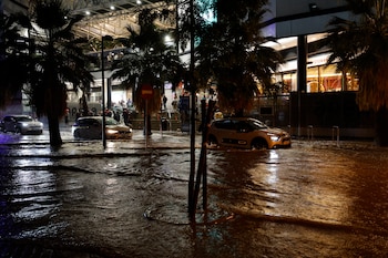 Coches circulan por una calle inundada tras las fuertes lluvias caídas en Valencia el miércoles. (EFE/ Ana Escobar)