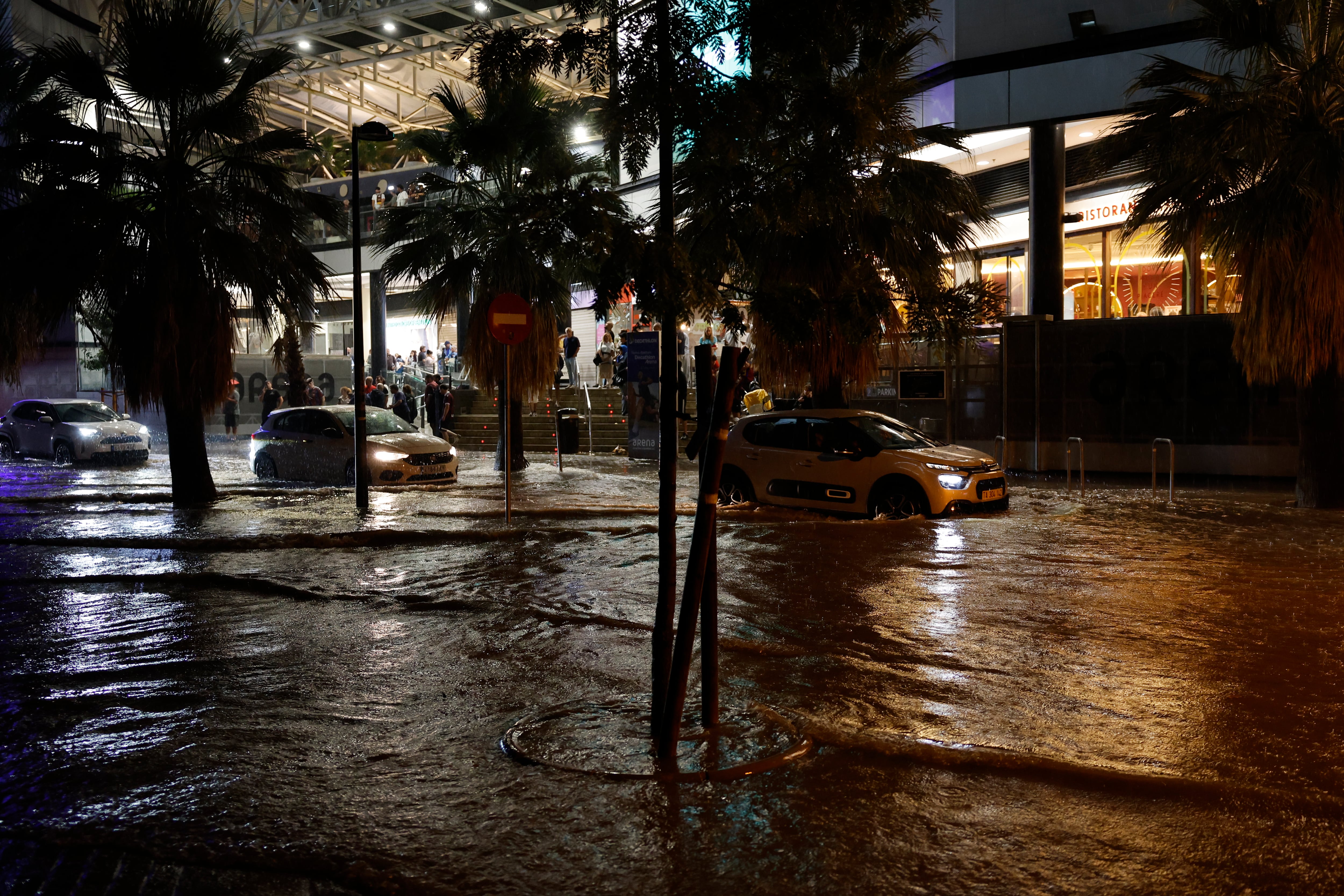 Coches circulan por una calle inundada tras las fuertes lluvias caídas en Valencia el miércoles. (EFE/ Ana Escobar)