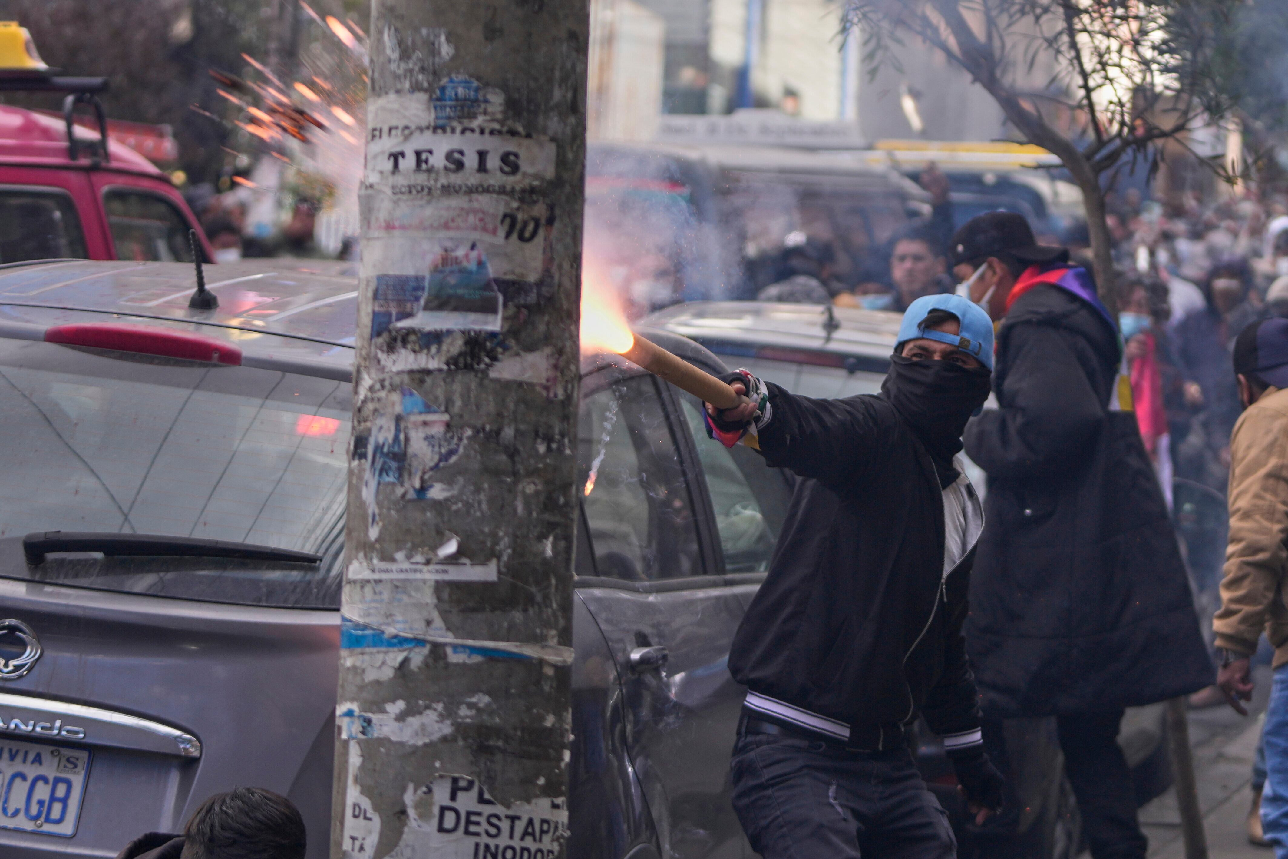 Un seguidor del expresidente Evo Morales lanza material pirotécnico a la policía, en una protesta en reclamo de su inhabilitación como candidato de cara a las próximas elecciones presidenciales, cerca del Tribunal Supremo Electoral en La Paz, Bolivia, el jueves 29 de mayo de 2025 (AP Foto/Juan Karita)