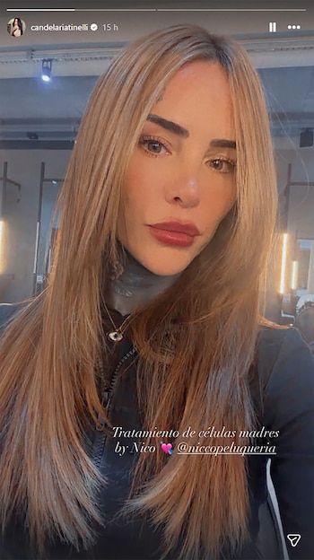Una mujer joven con cabello rubio largo y liso, labios rojos y un collar con un dije de ojo, mirando directamente a la cámara