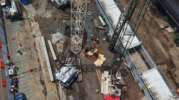 Vista aérea de un terreno en obra con grúas, vigas de concreto y obreros con cascos de protección