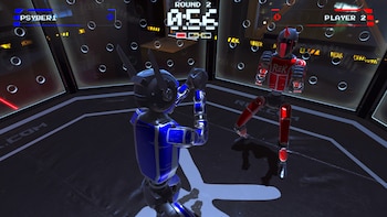 Un robot azul y otro rojo dentro de un cuadrilátero en un videojuego con interfaz que indica el tiempo y la ronda