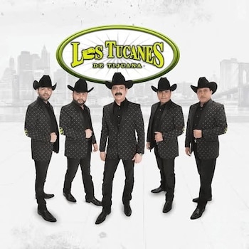 Cinco hombres vestidos con sombrero negro y saco estampado oscuro posan de pie delante del logotipo de Los Tucanes de Tijuana