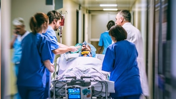 Varios sanitarios llevan en camilla a un paciente de gravedad por el pasillo de las urgencias de un hospital.