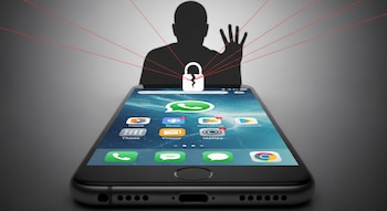 Un teléfono móvil con interfaz de WhatsApp en pantalla, una silueta espía desde atrás, un candado roto y líneas rojas conectando ambos. Fondo gris.