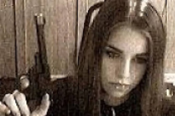 Joven con cabello oscuro y largo, mirando hacia abajo y a la derecha, sosteniendo un objeto oscuro similar a un arma en su mano izquierda. Imagen de baja resolución con tonos sepia