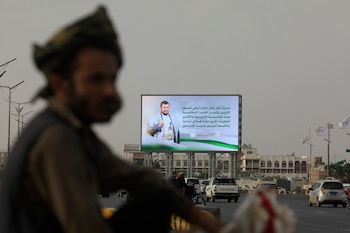 Vehículos fueron captados este 5 de septiembre al pasar ante una valla publicitaria digital en la que aparece el líder hutí Abdul-Malik al-Houthi, en una calle de Saná (Yemen). EFE/Yahya Arhab
