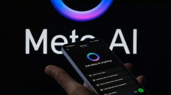 Primer plano de una mano sosteniendo un smartphone con la pantalla de Meta AI, mostrando un fondo negro y letras blancas. El logo de Meta AI de fondo.